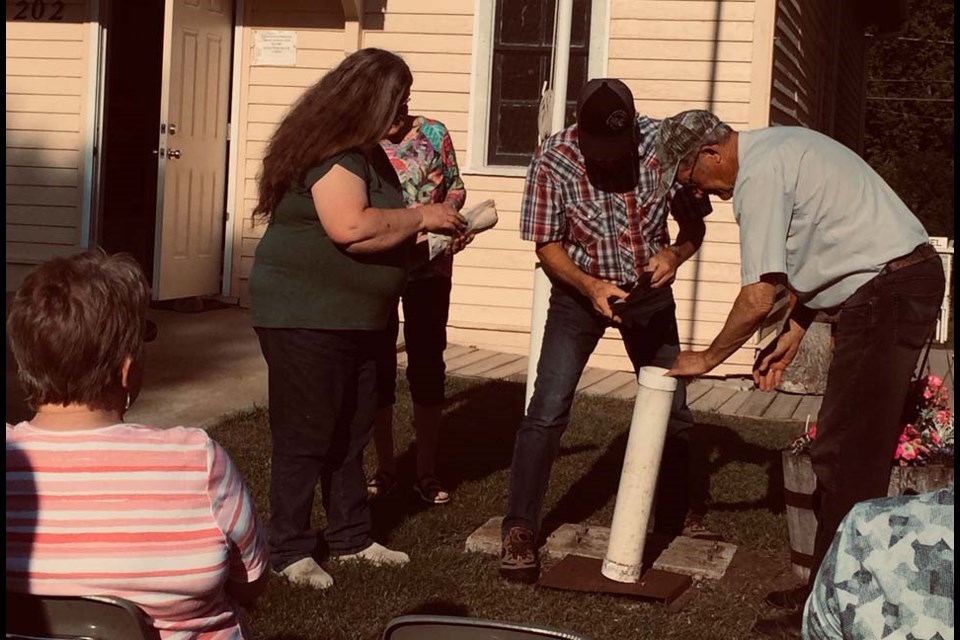 Borden Museum board members Karen Kerr, Heather Penner, Ruben Rempel and Ed Neufeld open a time capsule sealed in 2000. 
