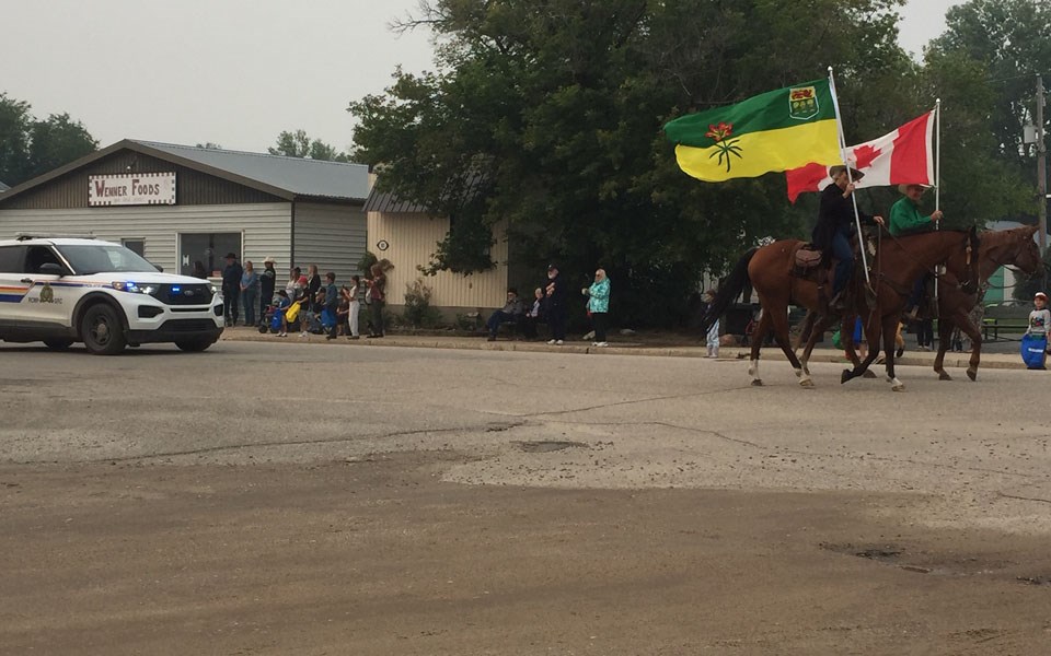 Flag bearers Dale and Diane Kieper, with the RCMP following to lead the parade.