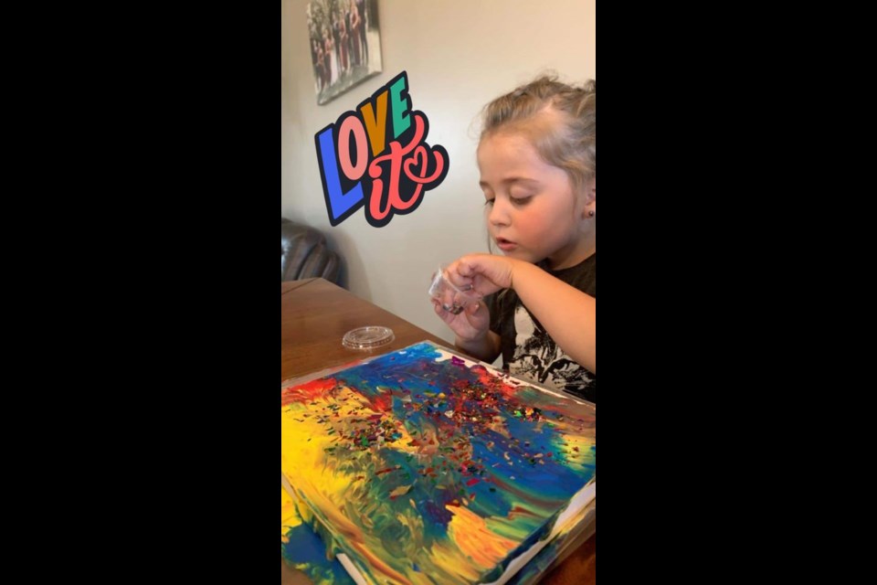 Aurora concentrating on her painting for a Wilkie Library craft project.