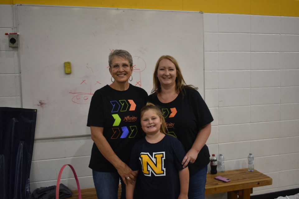 Two members from Affinity Credit Union, Chrissy Killniak, left, and Brenda Bowes and her daughter were in charge of giving out the burgers at the barbecue.