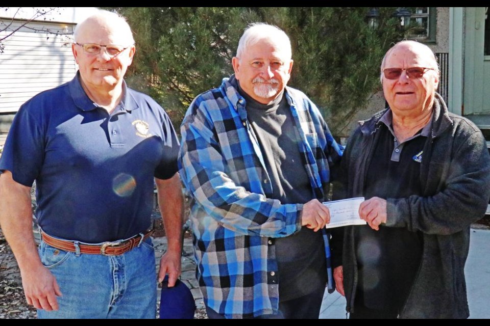 Knights of Columbus reps Richard Wick, left, and Bruno Tuchscherer, right, presented Myron Fletcher of the Weyburn Care-A-Van Society with a donation of $1,000 towards operations of the service.