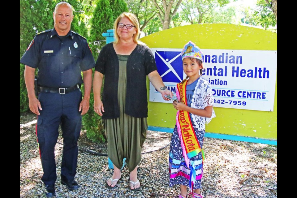 Jamie Blunden, vice-chair of the CMHA board of directors, and Tasha Collins, executive director for CMHA in Weyburn, accept a donation of $250 from Avra May Giesbrecht, 9, of Pheasant Rump First Nation on Wednesday.