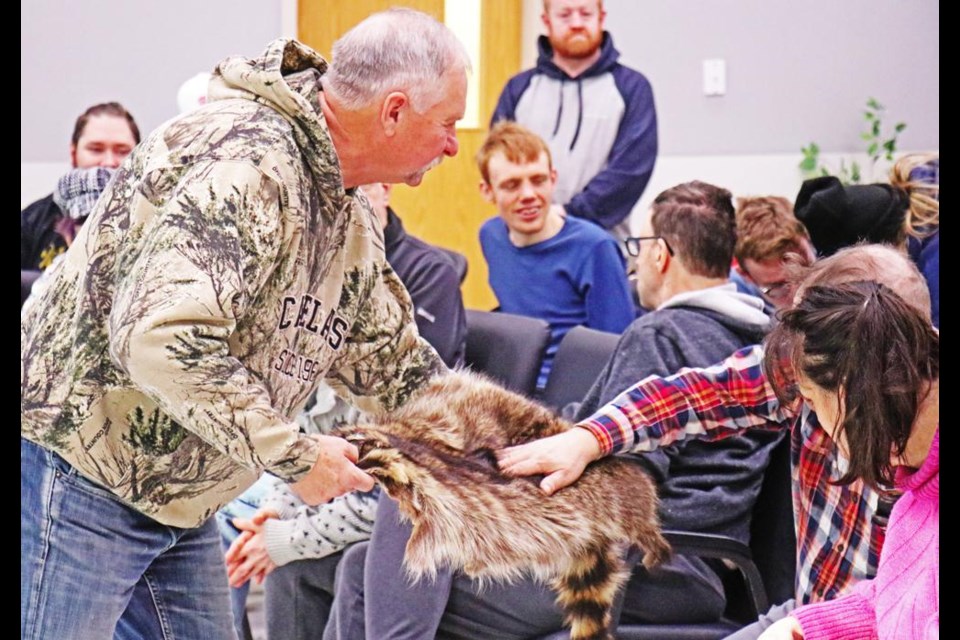 Dale Paslawski lets people stroke the fur of a coyote, during a presentation he made at the Weyburn Wor-Kin Shop on Thursday.