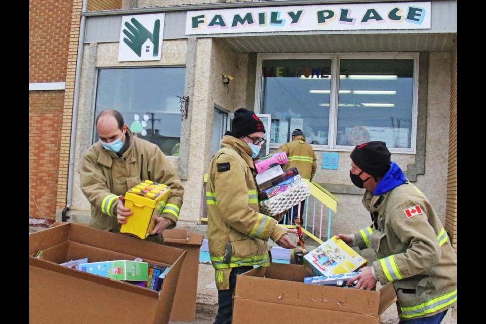 Weyburn fire fighters unload boxes of donated toys and carried them inside the Family Place on Monday.