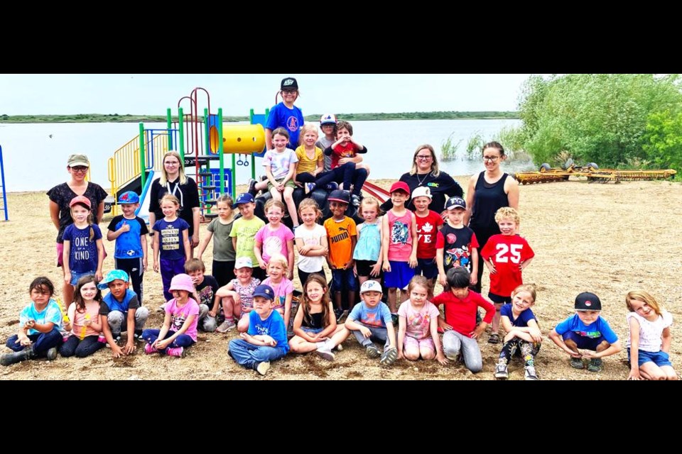 The kindergarten class from St. Michael School and members of the Weyburn Wildlife Federation gathered at the beach at Mainprize Regional Park on Friday to release the Rainbow trout fingerlings they had raised through the FINS program.