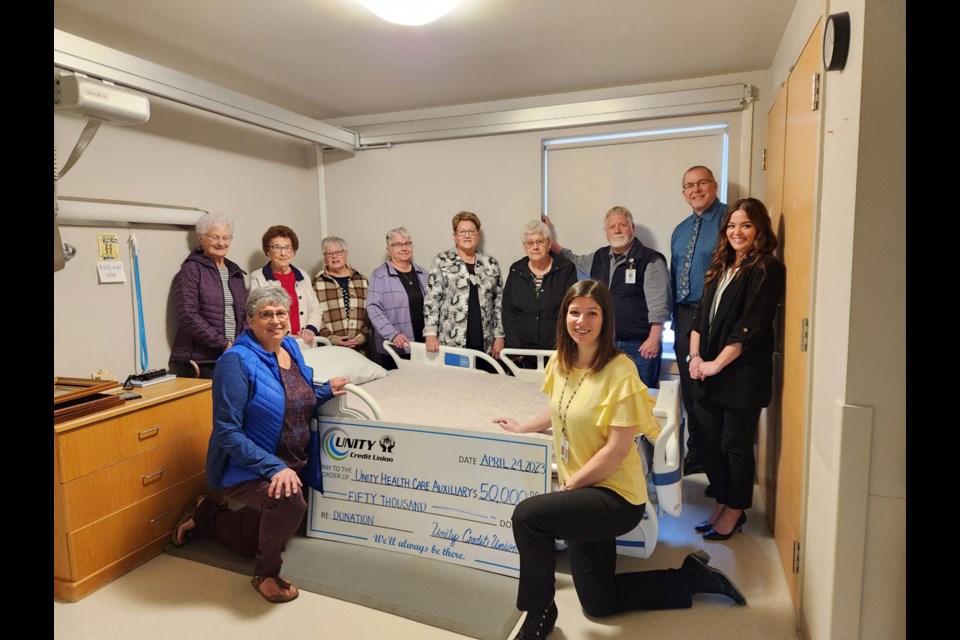 Members of Unity Health Care Auxiliary pose beside one of a number of new beds and mattressess purchased for Unity's Health Care Centre thanks in part to a recent donation from Unity Credit Union of $50,000.