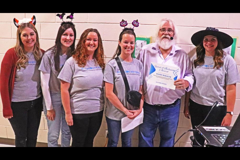 Representatives of Inclusion Weyburn presented the first-ever “Spirit of Inclusion” award to Randy Bakaluk at Inclusion’s Halloween dance on Wednesday evening at Dominic’s Place. From left are Alisa Sonnenberg, Jayda Messer, Meagan Rothwell, Kim Neithercut, Randy Bakaluk and Kaylyn Witzaney. The award recognizes Bakaluk for his volunteer efforts in support of Inclusion Weyburn, including being the DJ at the Halloween dance.