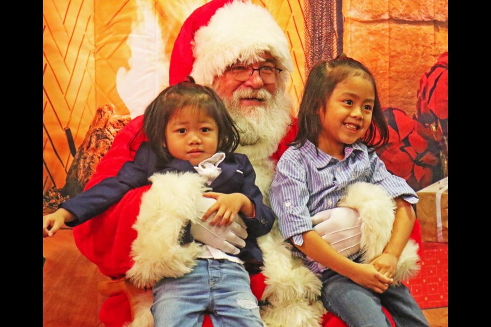 Santa held Aki and Breaden Samaniego, as they visited him during Inclusion Weyburn's sensory-free visits on Saturday at Zion Lutheran Church.