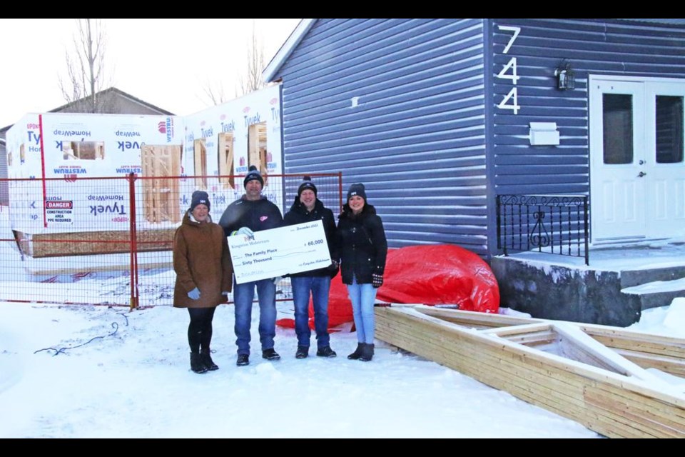 From left are Judy Lumb of the Family Place,  Darren Istace and Nolan Treble of Kingston Midstream, presenting a cheque for $60,000 to Dawn Gutzke, executive director of the Family Place on Dec. 22. To Dawn’s right are the roof trusses for the addition, and once they are installed, the contractor will be able to work on the interior of the addition through the winter, with the goal of the Family Place moving over in the month of June.