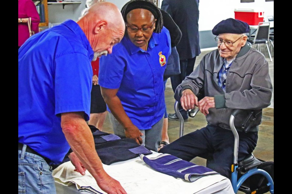 Legion member Jerry Ponto had a close look at a display of a service uniform from Don Wilkinson, at right, the last surviving veteran of the Second World War in Weyburn, during a meet-and-greet on Wednesday at the Weyburn Legion, along with chaplain Victoria Mwamasika.