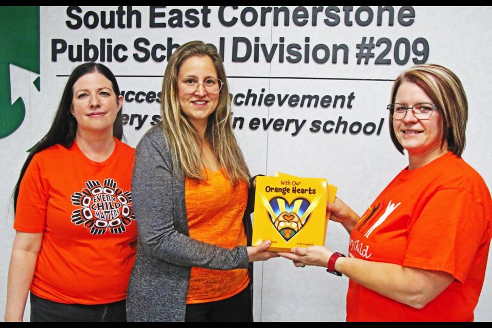 Michelle Neighbour of SWIS Estevan, and Maria Barranco of SWIS Weyburn, presented 35 books to Cheryl Anderson, coordinator of Student Services for SE Cornerstone.