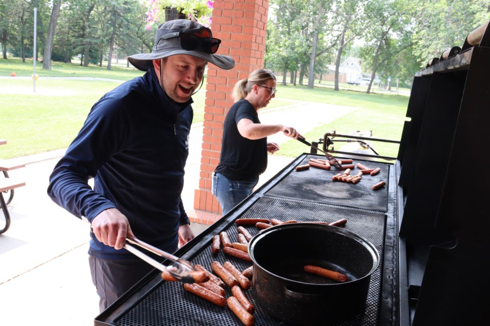 Andrew Crowe (director of Leisure Services) and Terri Stadnek (administrative coordinator) cook up hot dogs during the Party in the Park.