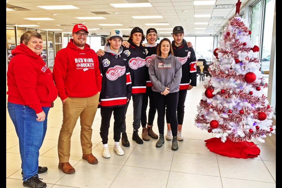 The first tree set up was by the Red Wings; from left are team president Jean Hobbs, coach/GM Cody Mapes, players Jakob Kalin, Matteo Speranza, Ty Mason and Ian Maier, and in front, alternate governor Alyssa Hanson.