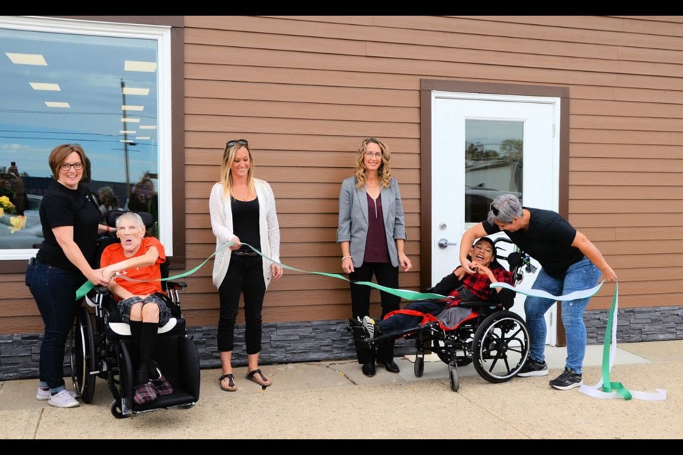 The ribbon has been cut and the new Prairie Branches head office and day program centre in Wilkie is officially opened.  L-R:  Tonya Elder, Wilkie program co-ordinator; Robert Holtorf,;Paige Danskin, board chair; Eunice Washkosky, executive director; Braden Herman, and Kerri Mercereau, residential manager