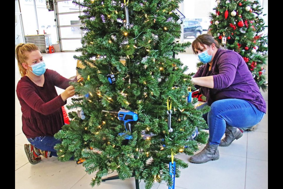 Kristen Iversen and Tammy Bachmier of DSI Contracting decorated their company's tree for the Festival of Trees fundraiser on Tuesday at Great Plains Ford. There are around 20 trees, half at the Ford dealership and half at Barber Motors, which will be auctioned off for the Family Place on Nov. 25 - they can be viewed by the public starting on Nov. 18.