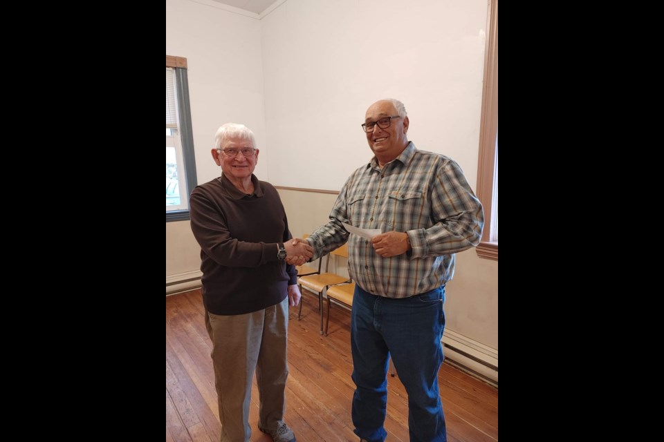Unity andDistrict Heritage Museum president Pat Uzelmanaccepts a donation from the Unity Kilwinning Masonic Lodge, as the service club has now ended.