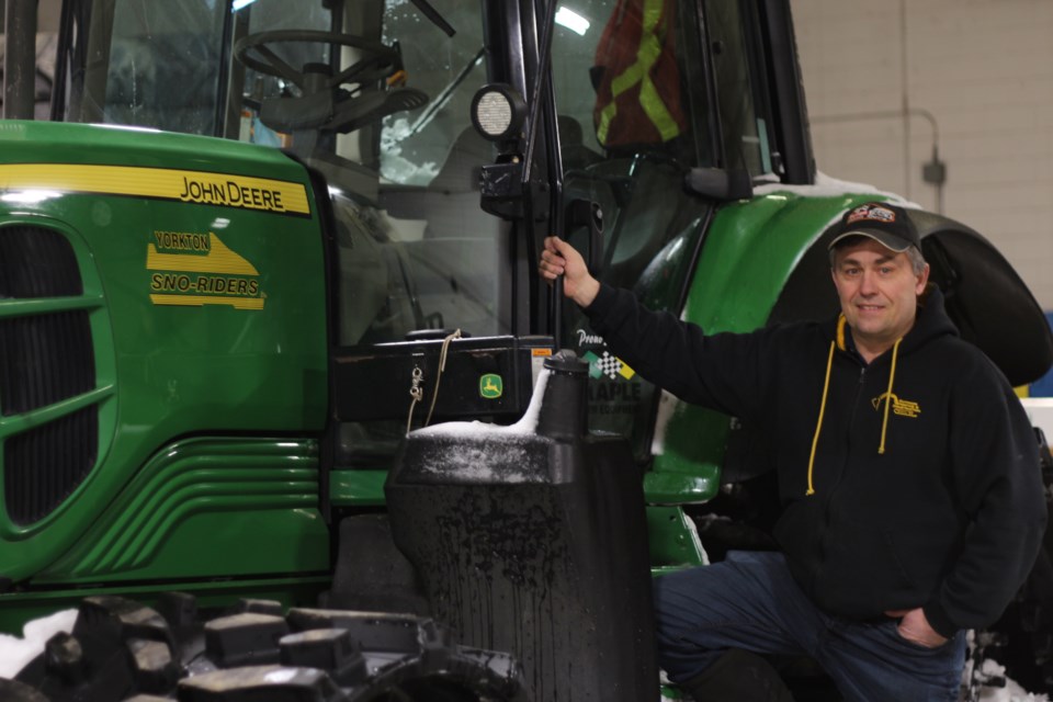 Jason Popowich, former President of the Yorkton Sno-Riders, stands next to one of three groomers used to maintain the trails.