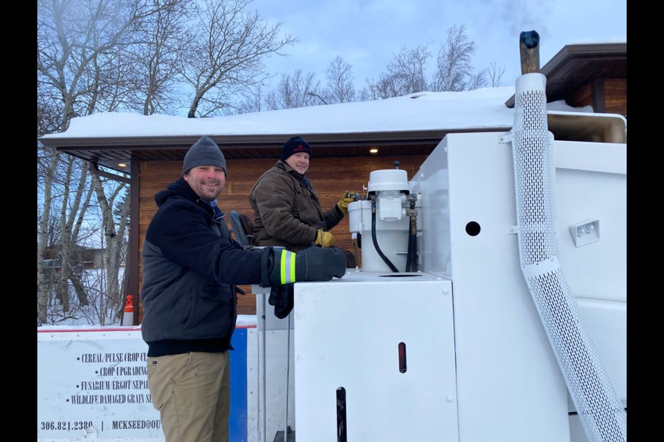 Lions members Kent Sauter and Brent Ruthven flooding the ice on the Zamboni. 
