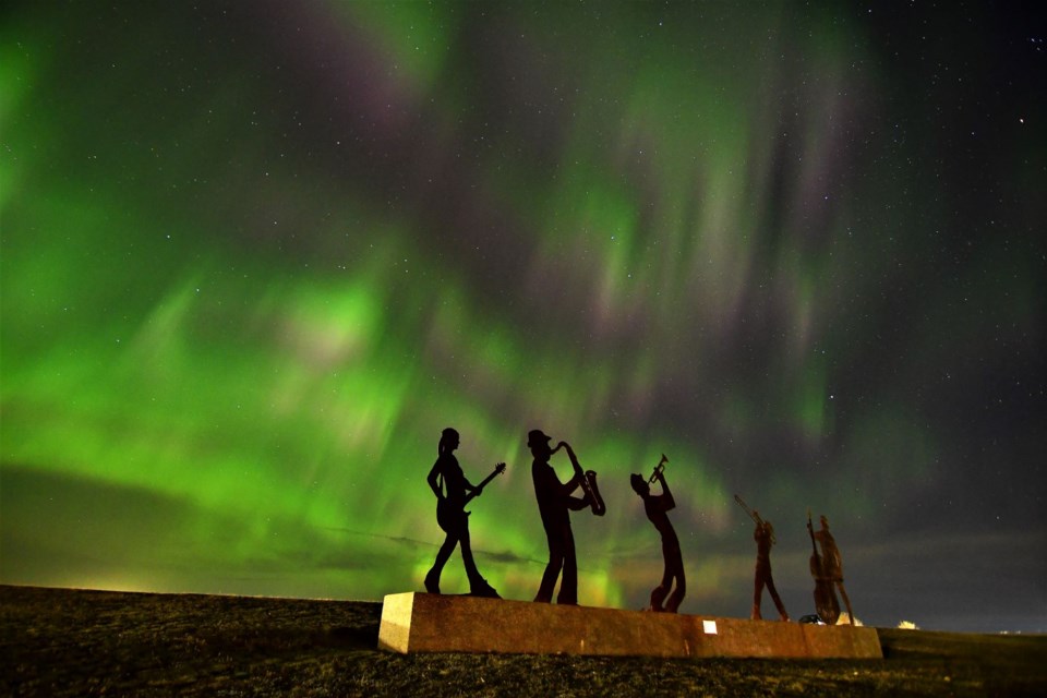 The northern lights surround the And the Band Played On metal sculpture on Thursday.