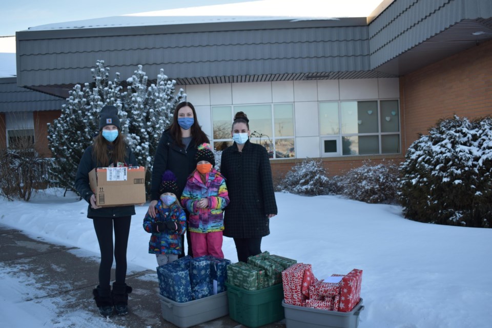 Audra Nelson, along with her daughters drops off scollection of Christmas gifts at Unity Long Term Care Centre, with Brianna Heck,  as part of her "adopt-a-grandparent" initiative.