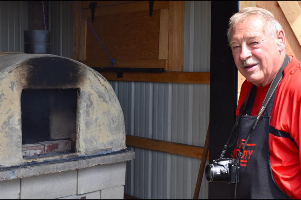 Harv Kasakoff stands beside the original clay oven used by early Doukhobor settlers. The oven was found in the Doukhobor Dugout House site. 