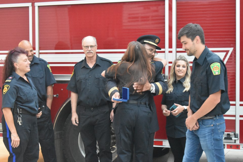 Fire Chief Ken Thompson was given a congratulatory hug for his commendation by one of his firefighters, Pam Rose.