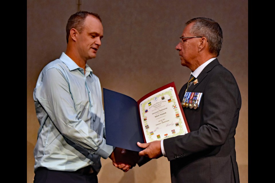 Mitch Hozack, left, receives a congratulatory handshake from Saskatchewan Lt.-Gov. Russell Mirasty after receiving the Honorary Testimonial Certificate in last week's Royal Canadian Humane Association Bravery Awards at TCU Place.