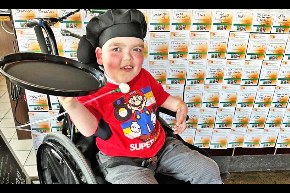 Isaiah Evans is shown in front of a wall of Isaiah cards at Leicester's Restaurant, part of the fundraising efforts to help him and his family.