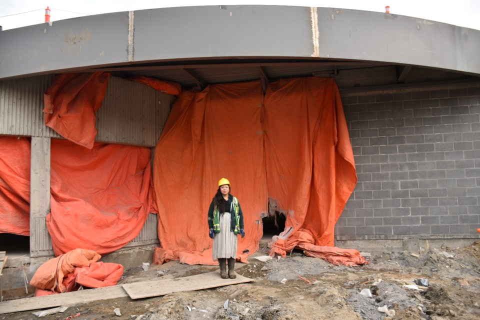 Larissa Kitchemonia stands in front the under-construction Wascana Pool entranceway. 