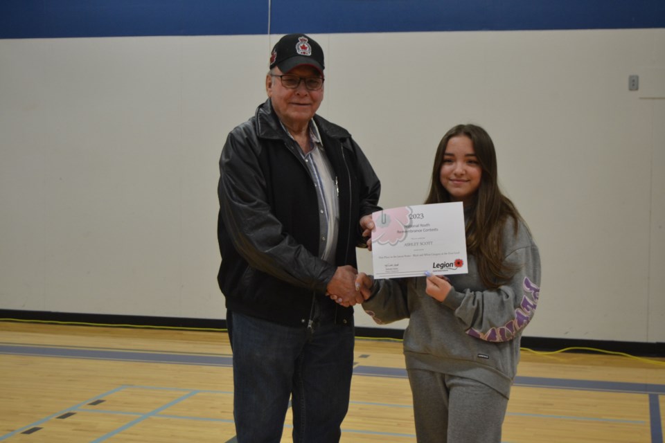 Blaine Medlang, left, presented Ashley Scott from the Preeceville School with a special certificate acknowledging her junior black and white poster that she had submitted during the Preeceville Legions Remembrance Day poster and essay contest.