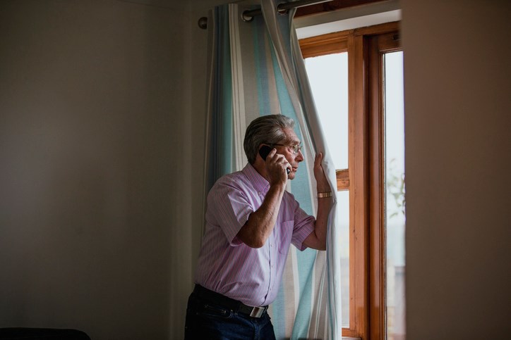 man peeking out of window