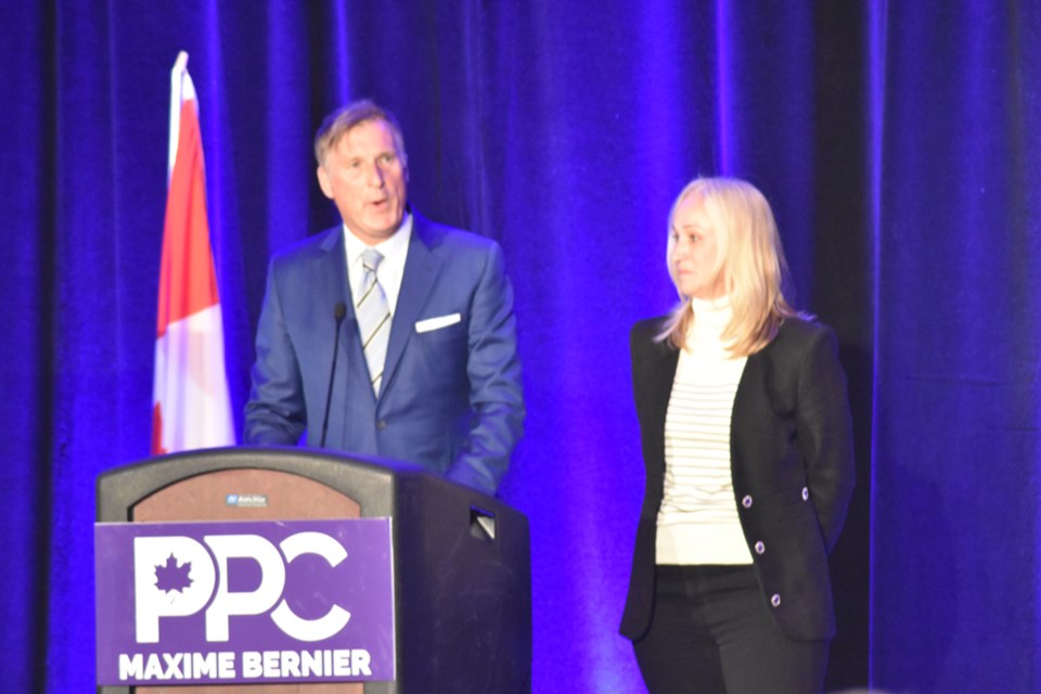 People's Party of Canada leader Maxime Bernier, left, addresses supporters while his wife Catherine Letarte listens during Monday night's election rally at the Saskatoon Inn.