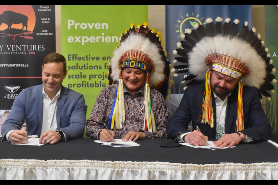 Mistawasis Nêhiyawak Chief Daryl Watson, center, leads the formal signing of their partnership with Meadow Lake Tribal Council Chief Richard Ben and miEnergy president Kevin Bergeron.