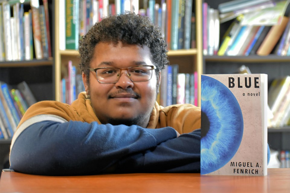 Writer Miguel Fenrich poses with a copy of Blue, his first novel.