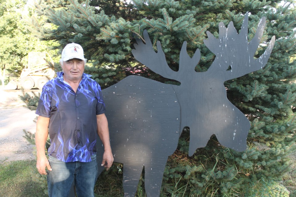 Gerry Swayze alongside his wooden moose replica.