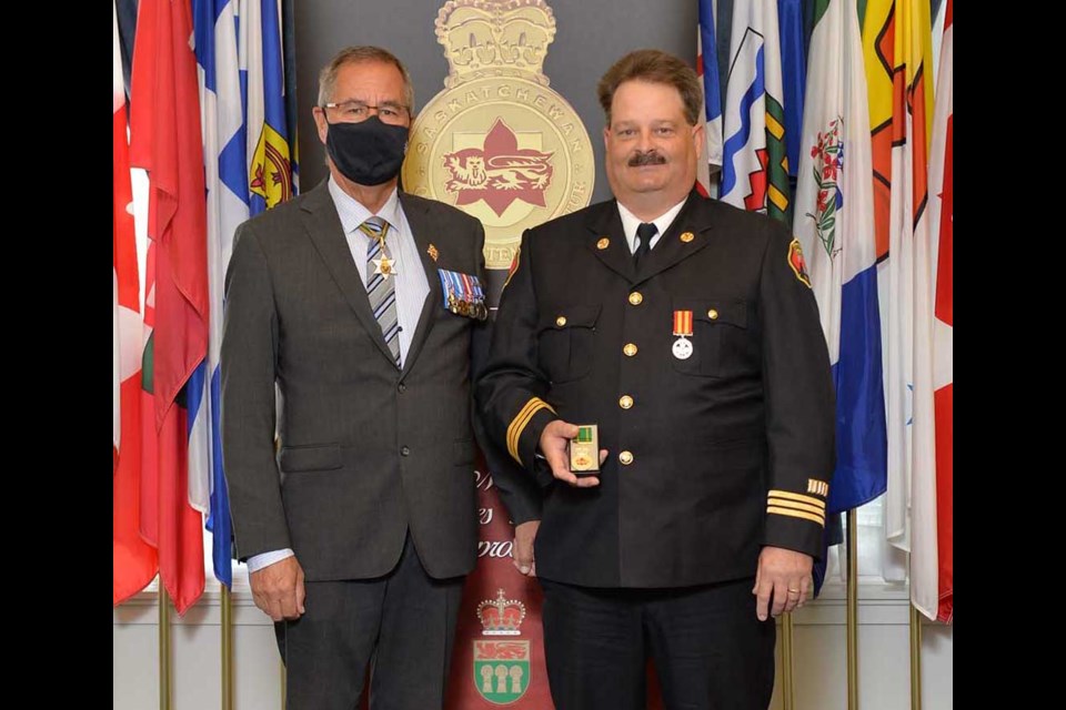 Platoon Chief Michael Kaip from the Weyburn Fire Department (at right) received a Saskatchewan Protective Services Medal from Lieutenant Governor Russ Mirasty.