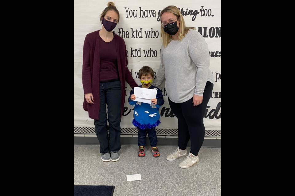 Michelle Kowerchuk and Nicole Lewis, staff members at Unity Public School, present the school's donation to Alvin Raycraft, brother to Frederick Raycraft currently undergoing stem cell treatment for the cancer he was diagnosed with.