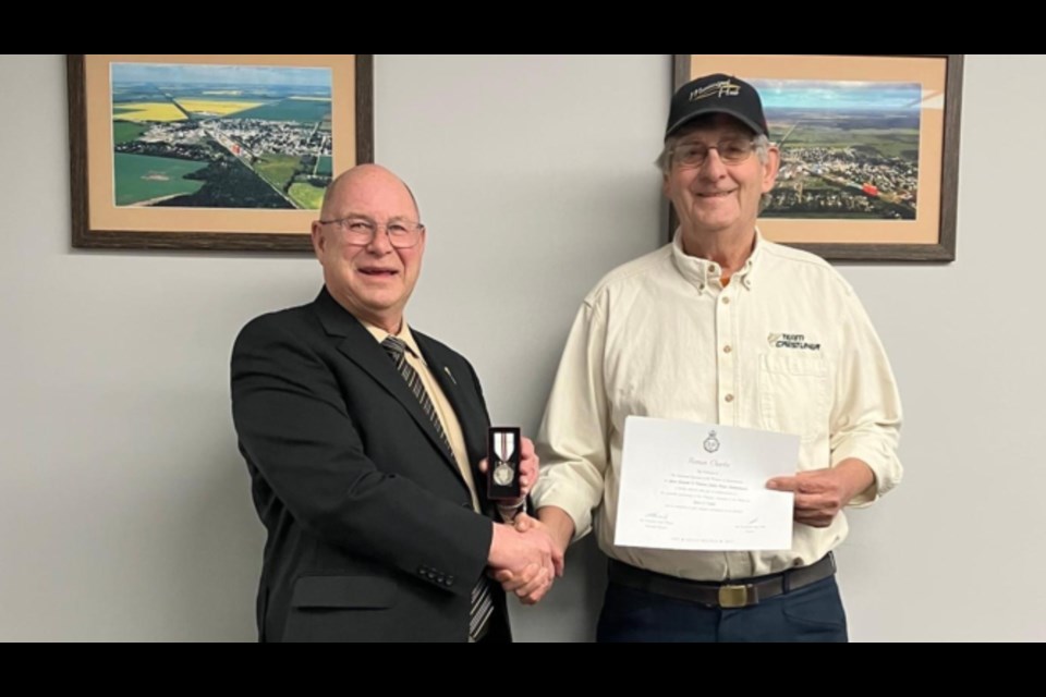 Roman Charko, right, received a Queen Elizabeth II Platinum Jubilee Medal for his volunteer efforts. Presenting the medal is Carrot River Valley MLA Fred Bradshaw, left.