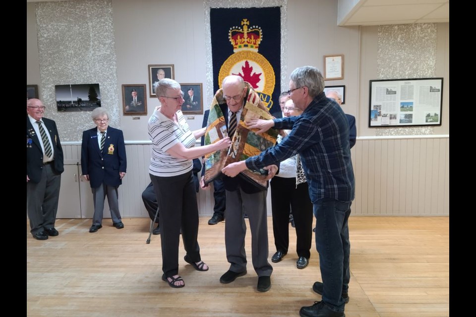 Following the spoken part of the "Canadian Quilts of Valour" presentation held at Unity's Legion Hall on May 21, the quilt is laid around the shoulders of the recipient to represent a warm embrace from Canadians in thanks for the veterans' service.