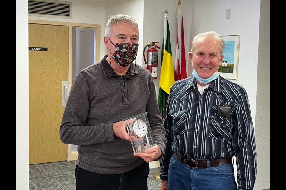 New chairperson, Alvin Bekemeier (right), presents a clock to Victor Delhommeau, former chairperson. of the Luseland Housing Authority.