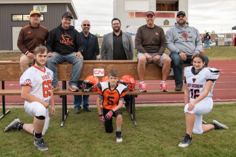 Winters,pictured here, unveiling the player benches at Kinsmen Century Field alongside, Roby Sharpe—President Yorkton Minor Football, Don McKenzie—Assistant Superintendent for CN, Rory Myhre—Superintendent CN, Jason Boyda—Director of Yorkton Minor Football, Tyrell Maclean—Head Coach Lady Gridders. Cam Reaney, Captain YRHS Football Team, Winters' son Brayden Winters and daughter Makayla Winters.