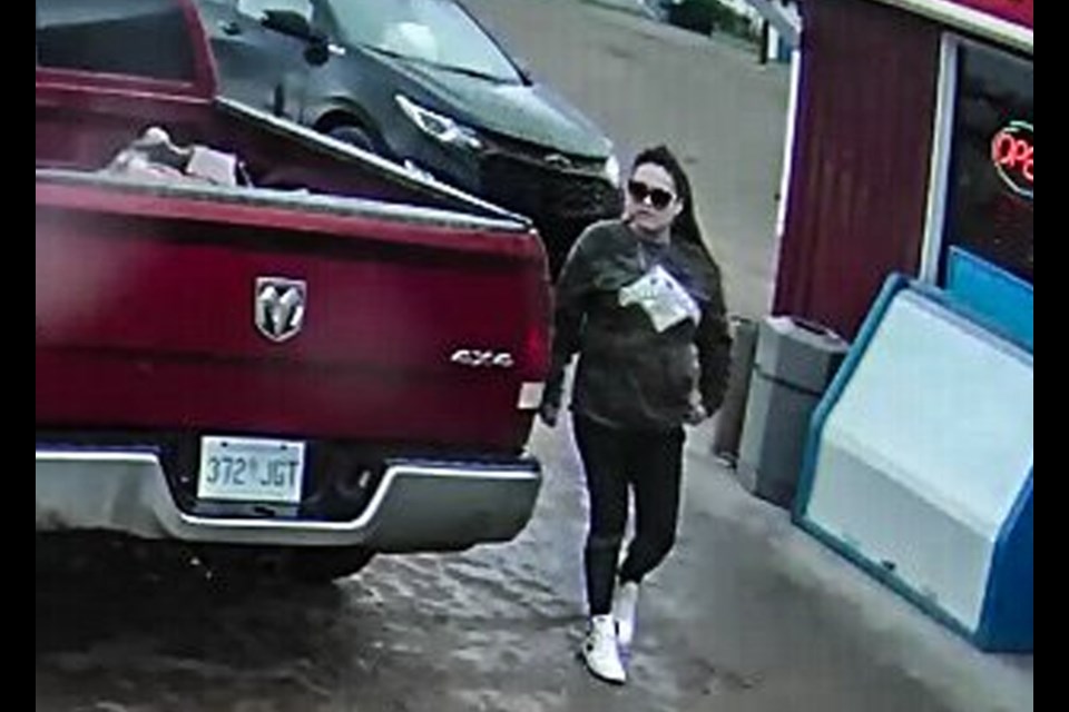 The female passenger pumped the gas while the male passenger waited inside the gas station.