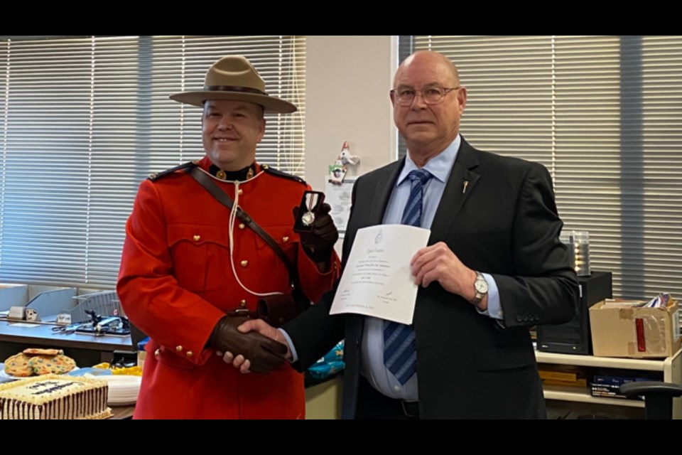Carrot River Fred Bradshaw, right, presents Cst. Dylan Custaloe with a Queen Elizabeth II Platinum Jubilee medal.