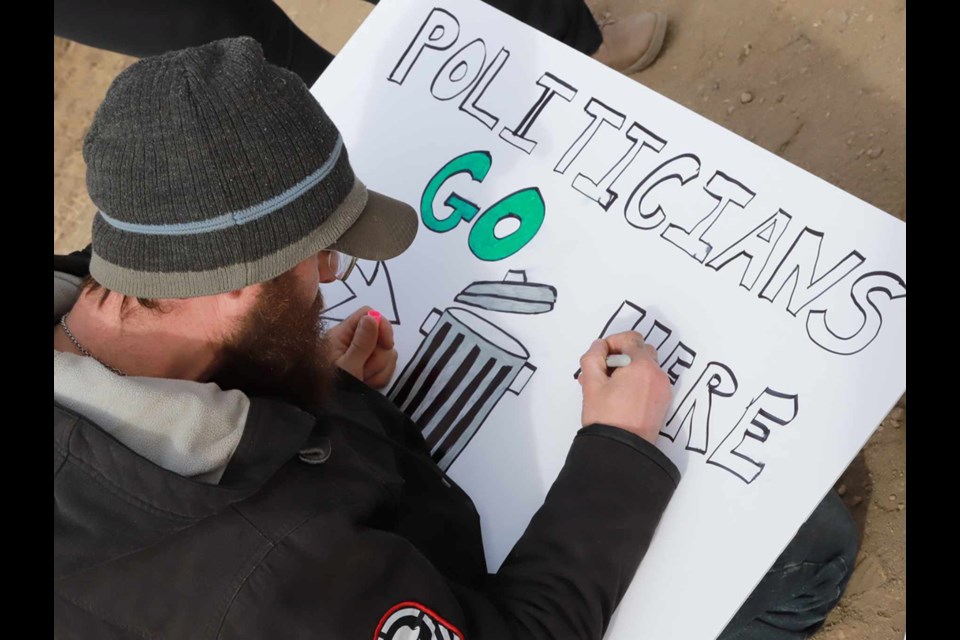 A protester at the Lloydminster, Alta., - North Battleford, Sask., protest along Highway 16, works on a sign. 