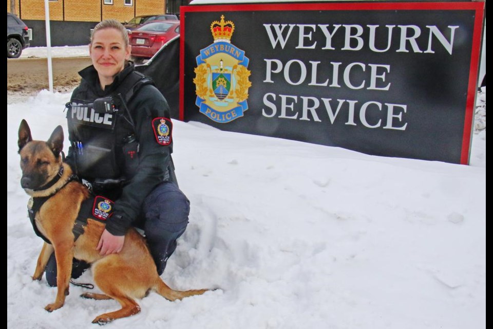 Const. Maralee McSherry posed with Oakley, Weyburn's first police dog, by the front sign