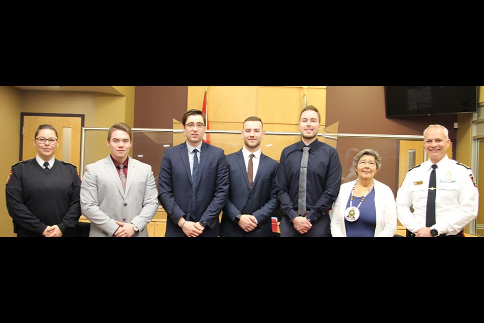 Pictured from left to right: Deputy Chief of Police Farica Prince; Cst. Ethan Ironside; Cst. Rhyse Teniuk; Cst. Tayler Milligan; Cst. Mathew Hagborg, PAPS Elder Liz Settee; Chief of Police Jonathan Bergen. 
