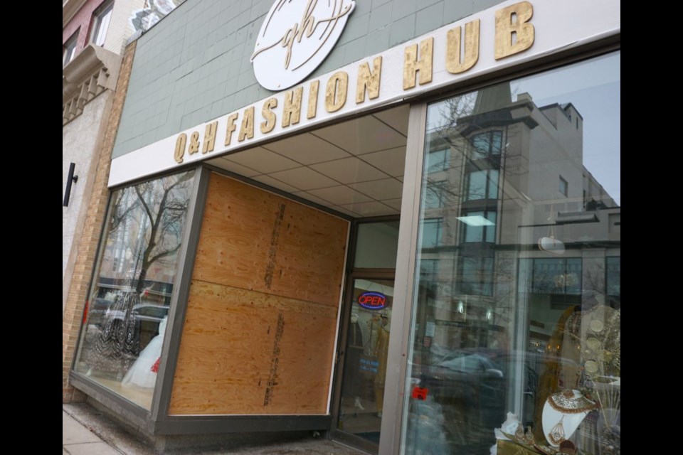 The store window is temporarily boarded up to prevent another break-in.