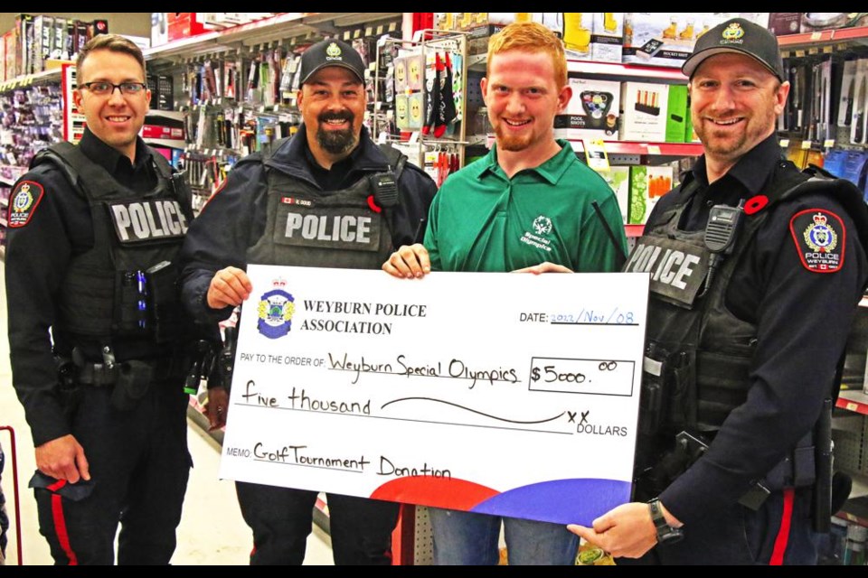 Representatives of the Weyburn Police Association presented a donation of $5,000 to Antonius Quist of Weyburn Special Olympics, to support local programming, including resuming the bowling teams for Special O athletes. From left are Const. Preston Roy, Cpl. Riley Doud and Const. Dallas Austin.
