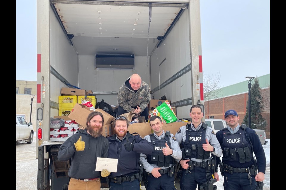 Members of Battlefords RCMP deliver the results of their Cram-a-Cruiser event in support of the local food bank. 