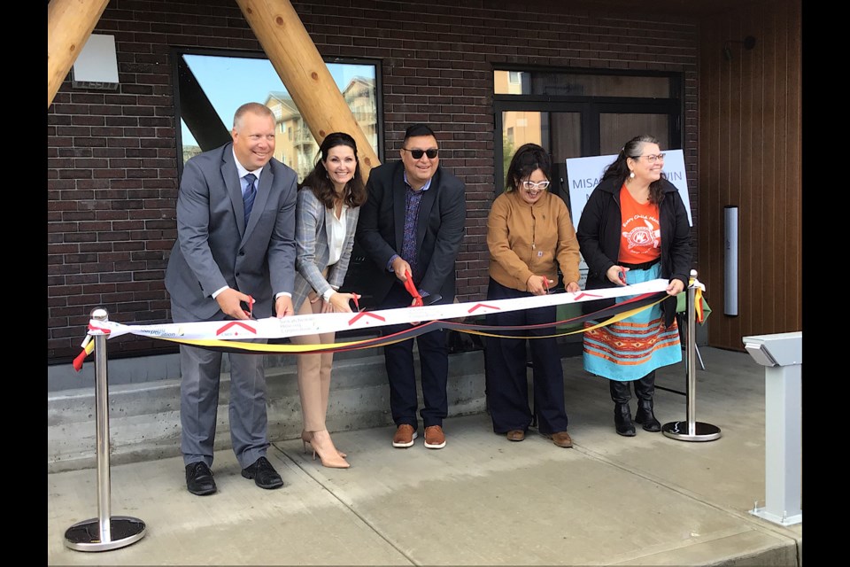 Dignitaries including Minister Gene Makowsky and Mayor Sandra Masters, are involved in the ribbon cutting marking the completion and opening of the rapid housing project.